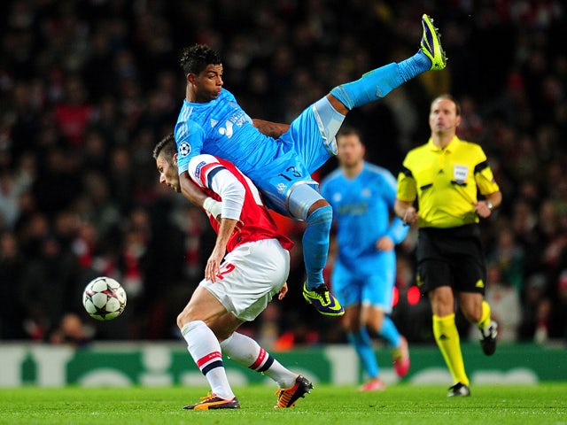 Mario Lemina of Marseille climbs on Olivier Giroud of Arsenal during the UEFA Champions League Group F match between Arsenal and Olympique de Marseille at Emirates Stadium on November 26, 2013