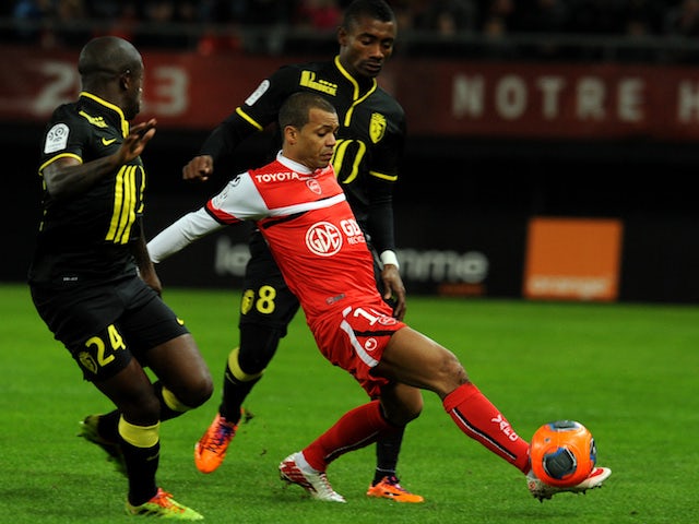 Valenciennes's Mathieu Dossevi vies with Lille's Salomon Kalou and Rio Mavuba during a French L1 football match on November 30, 2013