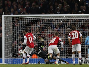 Marseille's French goalkeeper Steve Mandanda saves a penalty taken by Arsenal's German midfielder Mesut Ozil during the UEFA Champions League group F football match on November 26, 2013