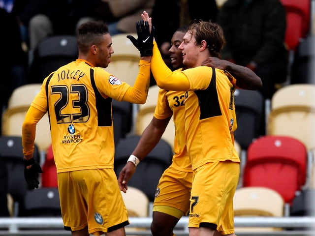 Adam Chapman of Newport celebrates with team mates after scoring his team's second goal of the game during the Sky Bet League Two match between Newport County AFC and Chesterfield at Rodney Parade on December 01, 2013