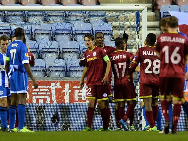 Zulte Waregem's Thorgan Hazard is congratulated by teammates after scoring his team's opening goal against Wigan during their Europa League group match on November 28, 2013