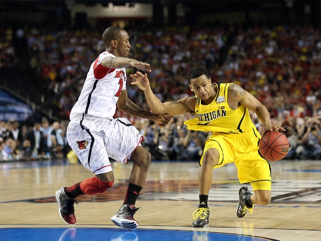Trey Burke #3 of the Michigan Wolverines drives against Russ Smith #2 of the Louisville Cardinals during the 2013 NCAA Men's Final Four Championship at the Georgia Dome on April 8, 2013