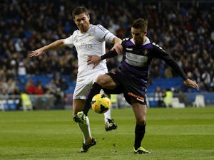 Real Madrid's midfielder Xabi Alonso vies with Valladolid's Italian midfielder Fausto Rossi during the Spanish league football match on November 30, 2013