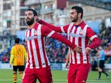 Atletico Madrid's Arda Turan celebrates with teammate Adrian Lopez after scoring his team's second goal against Sant Andreu during their Copa del Rey on December 7, 2013