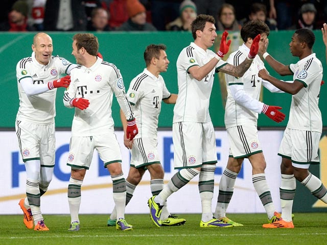 Bayern Munich's Arjen Robben is congratulated by teammates after scoring the opening goal against Augsburg during their 3rd round German Cup match on December 4, 2013