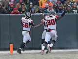 Sean Weatherspoon #56 of the Atlanta Falcons crosses the goalline with teammates including Stansly Maponga #90 after intercepting a pass for a touchdown against the Green Bay Packers at Lambeau Field on December 8, 2013