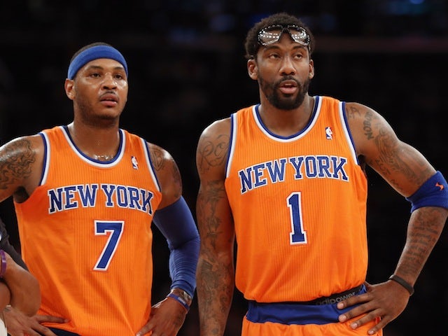 Carmelo Anthony and Amar'e Stoudemire of the New York Knicks watch on against the Boston Celtics at Madison Square Garden on December 8, 2013