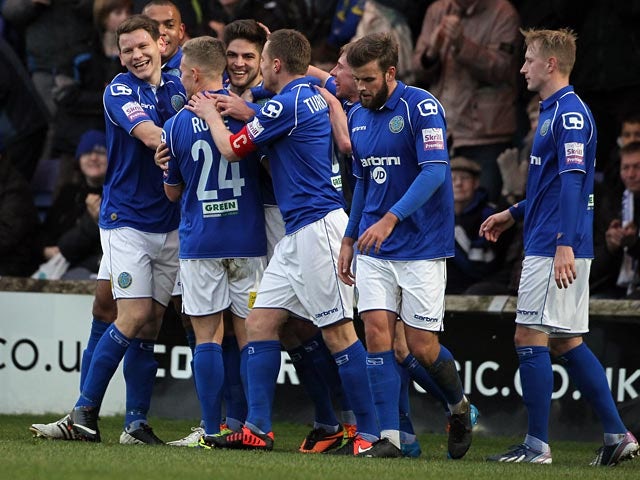 Macclesfield's Danny Andrew is congratulated by teammates after scoring the opening goal against Brackley during their FA Cup second round match on December 7, 2013