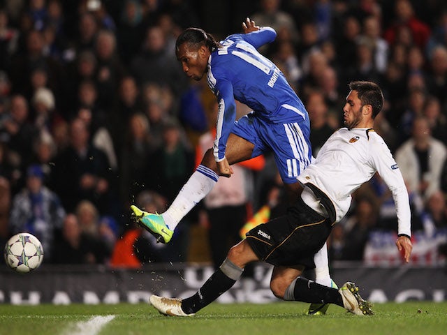 Didier Drogba of Chelsea shoots past Victor Ruiz of Valencia during the UEFA Champions League Group E match between Chelsea FC and Valencia CF at Stamford Bridge on December 6, 2011