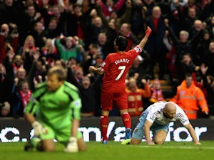 Luis Suarez of Liverpool celebrates after Guy Demel of West Ham United scored an own goal during the Barclays Premier League match between Liverpool and West Ham United at Anfield on December 7, 2013