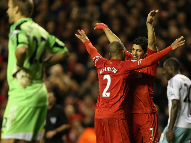 Luis Suarez of Liverpool celebrates scoring his team's third goal with team-mate Glen Johnson during the Barclays Premier League match between Liverpool and West Ham United at Anfield on December 7, 2013