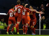 Liverpool's Luis Suarez is congratulated by teammates after scoring the opening goal against Norwich during their Premier League match on December 4, 2013
