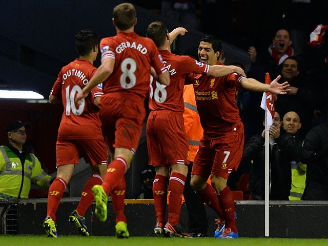 Liverpool's Luis Suarez is congratulated by teammates after scoring the opening goal against Norwich during their Premier League match on December 4, 2013