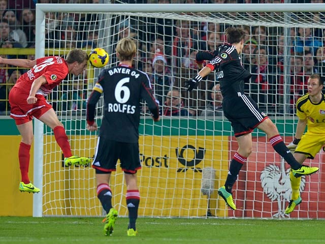 Freiburg's Matthias Ginter heads in his team's opening goal against Bayer Leverkusen during the 3rd round of the German Cup on December 4, 2013