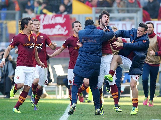 Roma's Mattia Destro celebrates with teammates after scoring his team's second goal against Fiorentina during their Serie A match on December 8, 2013