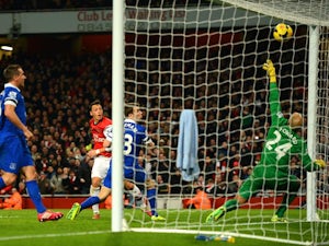 Arsenal's Mesut Ozil heads in the opening goal against Everton during their Premier League match on December 8, 2013