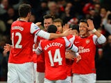 Arsenal's Mesut Ozil celebrates with teammates after scoring the opening goal against Everton during their Premier League match on December 8, 2013