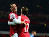 Arsenal's Mesut Ozil celebrates with teammate Nacho Monreal after scoring his team's second goal against Hull during their Premier League match on December 4, 2013