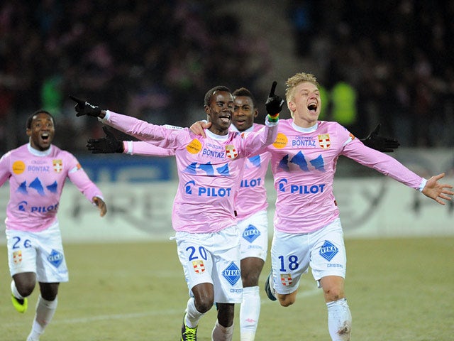 Evian's Modou Sougou celebrates with teammates after scoring his team's second goal against PSG during their Ligue 1 match on December 4, 2013