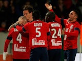 Nolan Rouxof Lille celebrates with teammates after he scores the first goal of the game in the final minutes by kissing Florent Balmont on the head during the Ligue One match on December 3, 2013