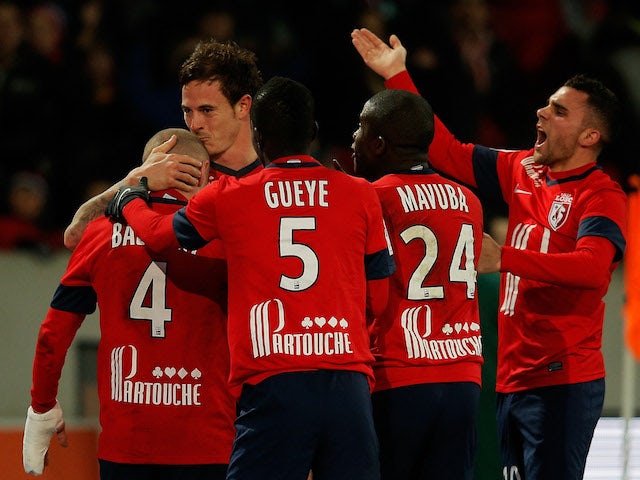 Nolan Rouxof Lille celebrates with teammates after he scores the first goal of the game in the final minutes by kissing Florent Balmont on the head during the Ligue One match on December 3, 2013