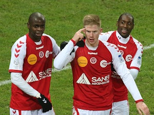 Reims' Gaetan Charbonnier (C) is congratulated by teammates after scoring a goal during the French L1 football match Reims vs Nice, on December 7, 2013
