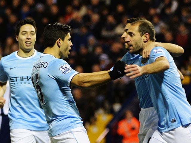 Man City's Sergio Aguero celebrates with teammates after scoring his team's opening goal against West Brom during their Premier League match on December 4, 2013