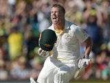 Australian batsman David Warner celebrates making his 100 runs on the third day of the third Ashes cricket Test match against England in Perth on December 15, 2013