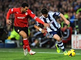 Steven Caulker of Cardiff City and Shane Long of West Bromwich Albion chase the ball during the Barclays Premier League match between Cardiff City and West Bromwich Albion at Cardiff City Stadium on December 14, 2013
