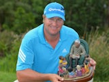 Dawie Van Der Walt of South Africa holds the trophy after winning the Nelson Mandela Championship at Mount Edgecombe Country Club on December 14, 2013