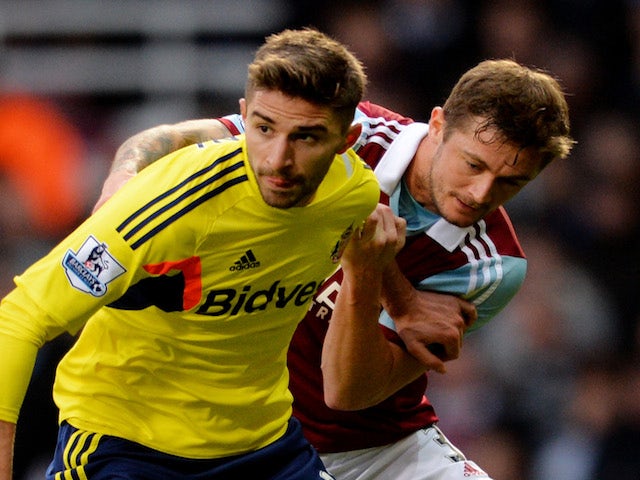 Fabio Borini of Sunderland is challenged by George McCartney of West Ham during the Barclays Premier League match between West Ham United and Sunderland at Boleyn Ground on December 14, 2013