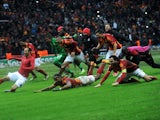 Galatasaray players slide at the Turk Telecom Arena to celebrate their victory over Juventus in the Champions League on December 11, 2013