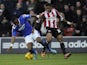 Genseric Kusunga of Oldham Athletic is tackled by Kadeem Harris of Brentford during the Sky Bet League One match between Brentford and Oldham Athletic at Griffin Park on December 14, 2013