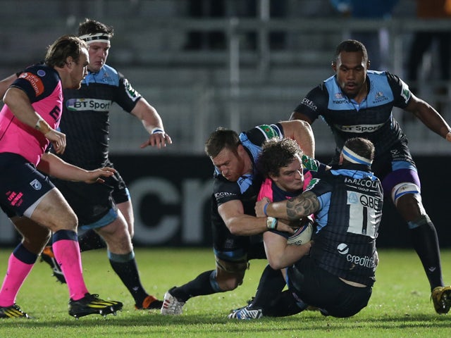 Rory Watts-Jones of Cardiff is tackled by Tyrone Holmes of Glasgow and Ryan Grant of Glasgow during the The Heineken Cup Pool 2 Match between Glasgow Warriors and Cardiff Blues at Scotstoun Stadium, on December 13, 2013
