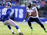 Marshawn Lynch of the Seattle Seahawks carries the ball as Prince Amukamara of the New York Giants defends at MetLife Stadium on December 15, 2013