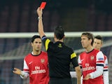 Referee Viktor Kassai shows the red card to Mikel Arteta of Arsenal during the UEFA Champions League Group F match between SSC Napoli and Arsenal on December 11, 2013