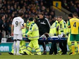 Nathan Dyer of Swansea City is carried off the pitch on a stretcher after being injured during the Premier League match between Norwich City and Swansea City at Carrow Road on December 15, 2013