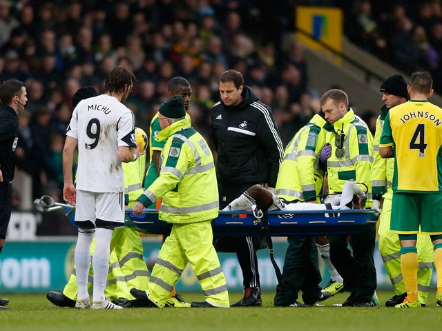 Nathan Dyer of Swansea City is carried off the pitch on a stretcher after being injured during the Premier League match between Norwich City and Swansea City at Carrow Road on December 15, 2013