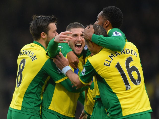 Gary Hooper of Norwich celebrates scoring their first goal with team mates during the Barclays Premier League match between Norwich City and Swansea City at Carrow Road on December 15, 2013