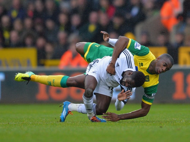 Nathan Dyer of Swansea looks in pain as he lands on his ankle and later leaves the field on a stretcher after Seb Bassong of Norwich lands on top of him after they both go for the header during the Barclays Premier League match between Norwich City and Sw