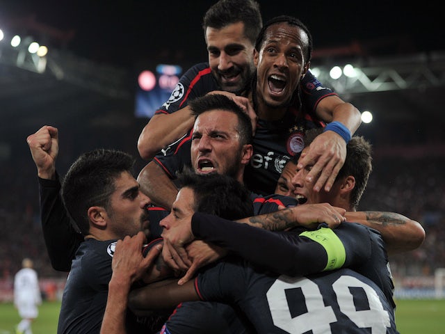 Olympiakos' players celebrate after scoring a goal during the UEFA Champions League group C football match between Olympiakos and Anderlecht at the Karaiskaki stadium in Athens on December 10, 2013
