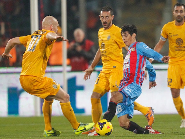 Pablo Barrientos (R) of Catania competes for the ball with Emil Halfredsson of Hellas Verona during the Serie A match on December 14, 2013