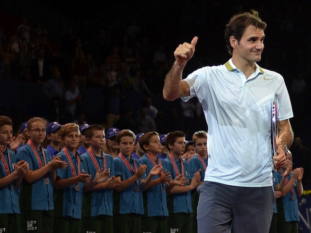 Roger Federer gives a thumbs-up after collecting the runner-up trophy at the Swiss Indoors ATP tennis tournament in Basel on October 27, 2013
