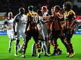 Swansea and Hull players clash during the Barclays Premier league match between Swansea City and Hull City at the Liberty Stadium on December 9, 2013