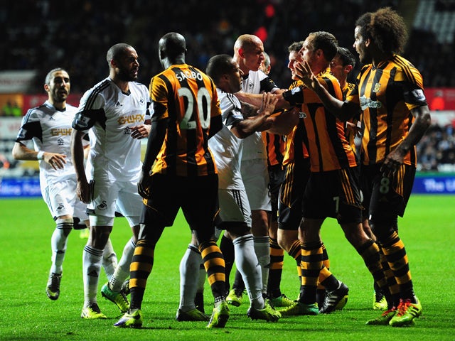 Swansea and Hull players clash during the Barclays Premier league match between Swansea City and Hull City at the Liberty Stadium on December 9, 2013