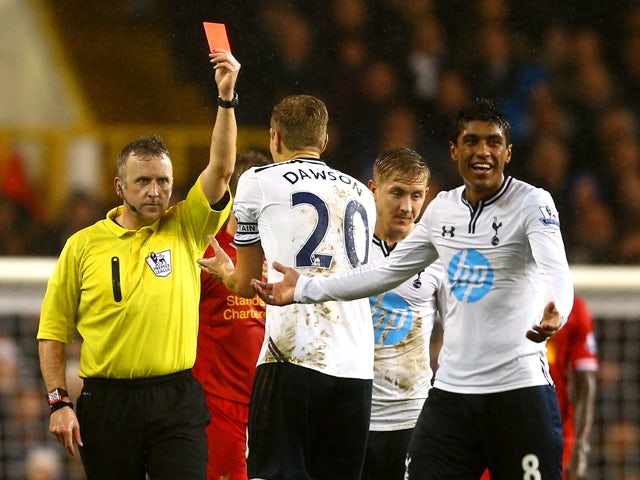 Referee Jonathan Moss shows Paulinho of Tottenham Hotspur a red card for a foul on Luis Suarez of Liverpool during the Barclays Premier League match between Tottenham Hotspur and Liverpool at White Hart Lane on December 15, 2013