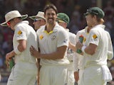 Australian bowler Mitchell Johnson celebrates with teammates after dismissing England batsman Joe Root on the fourth day of the third Ashes cricket Test match in Perth on December 16, 2013
