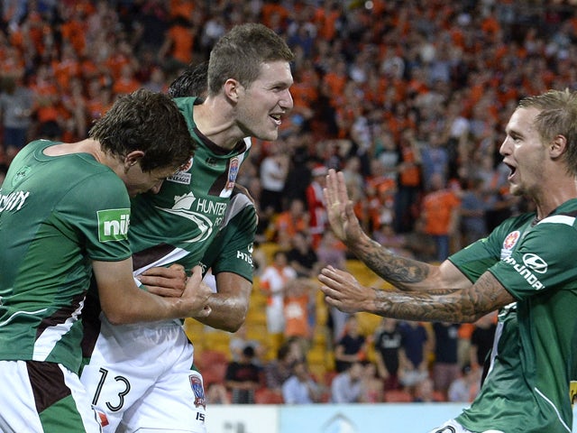 Joseph Gibbs of the Jets celebrates with team mates after scoring a goal to seal the victory during the round 11 A-League match between Brisbane Roar and the Newcastle Jets at Suncorp Stadium on December 20, 2013 