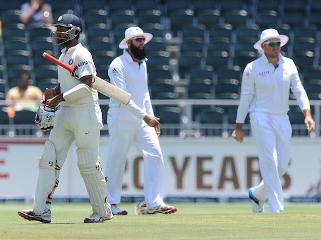 Indian batsman Cheteshwar Pujara walks off the field after being bolwed by South African bowler Jacques Kallis on the fourth day of a cricket Test match on December 21, 2013