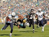 Shonn Greene of the Tennessee Titans runs through Josh Evans of the Jacksonville Jaguars during a game at EverBank Field on December 22, 2013